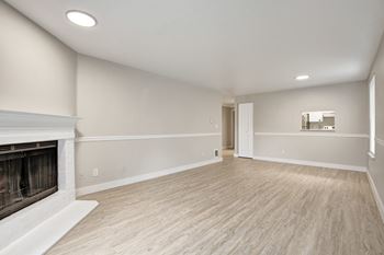 open-concept living room with a fireplace and wood-style flooring at 2000 Lake Washington Apartments, Renton